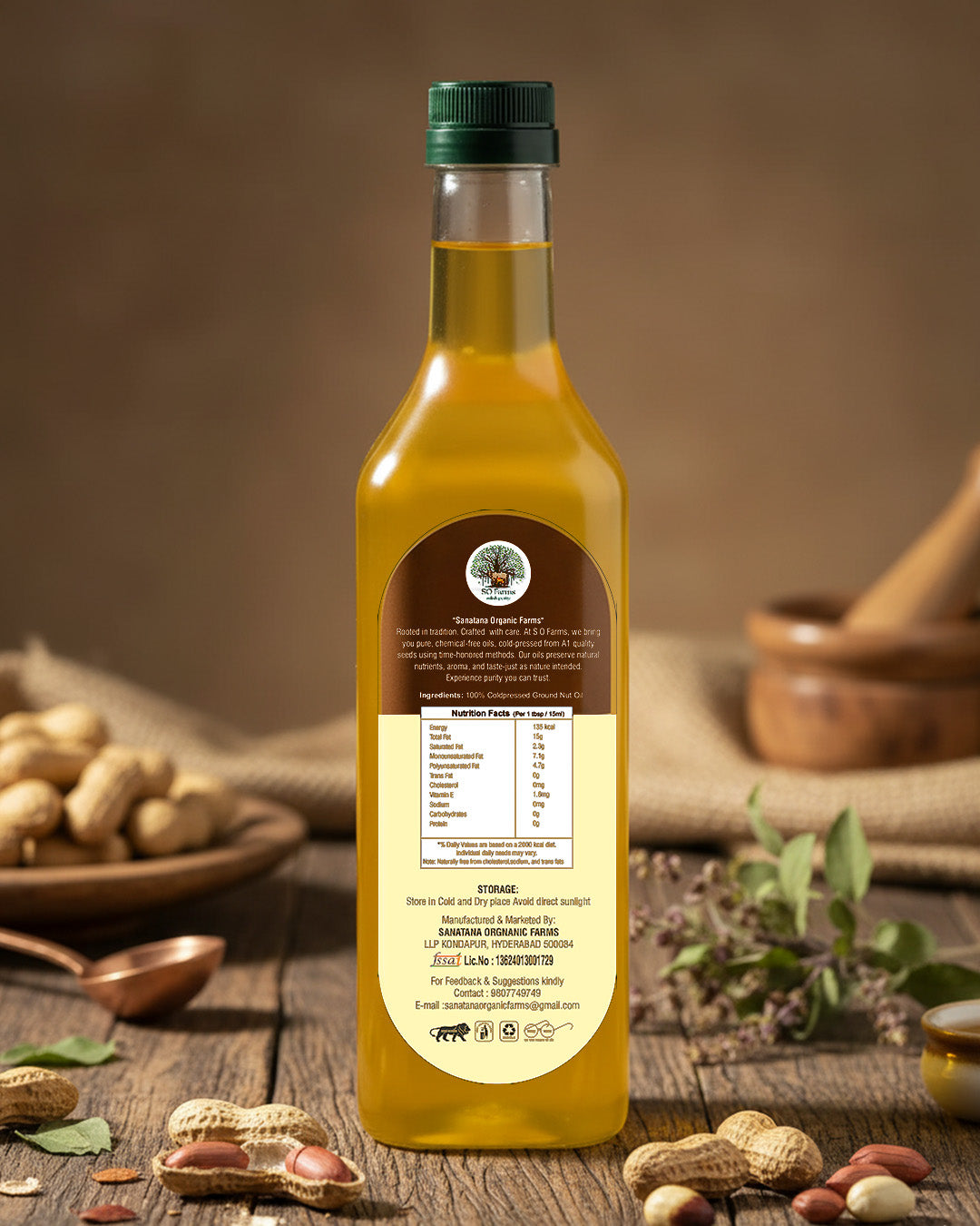 Bottle of peanut oil with a label on a rustic wooden table with peanuts and a mortar and pestle.